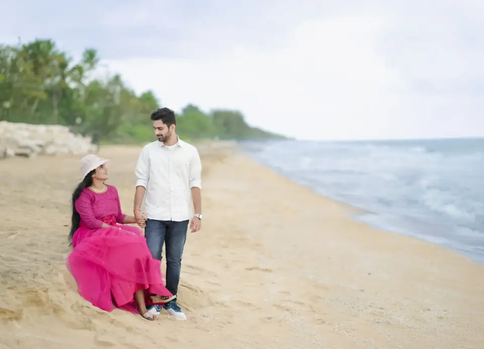 Couple relaxing on the beach with palms behind them