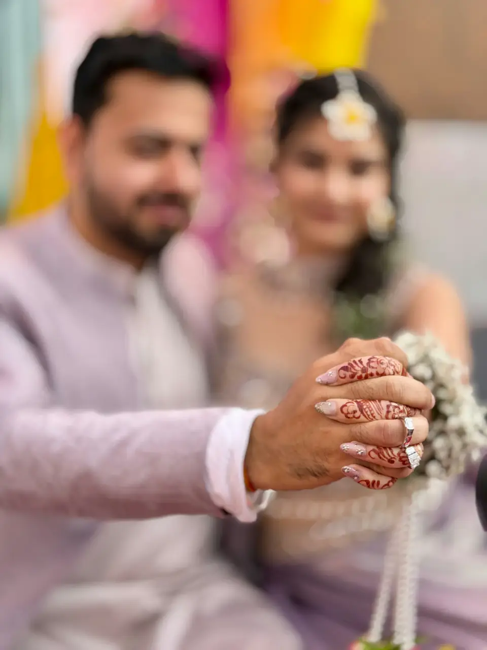 Close-up of the engagement ring and bridal mehendi as the couple hold hands