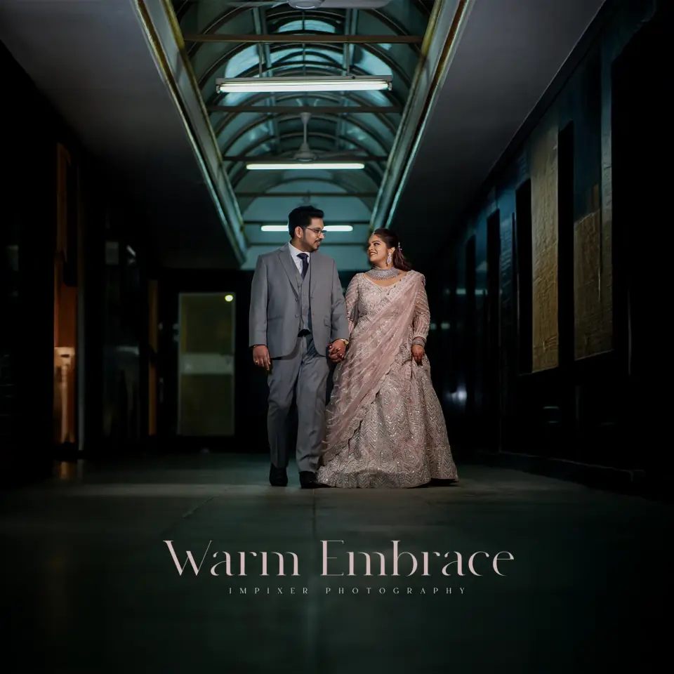 Couple walking hand in hand through a lit corridor, cinematic reception portrait